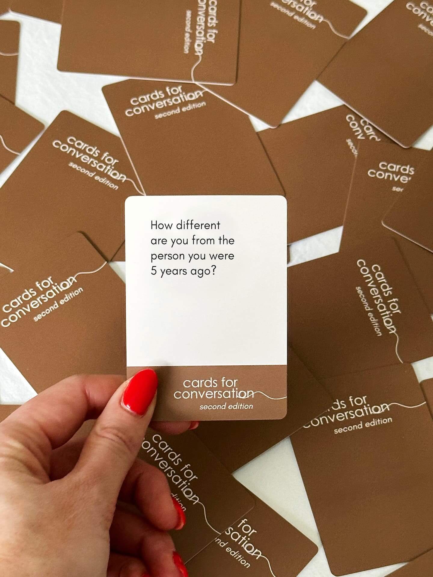 Hand holding a prompt card from Cards for Conversation: Second Edition with a question about personal growth.