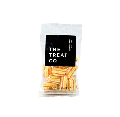 Pineapple Bonbons in a clear bag from The Treat Co, showcasing vibrant yellow and orange stripes.